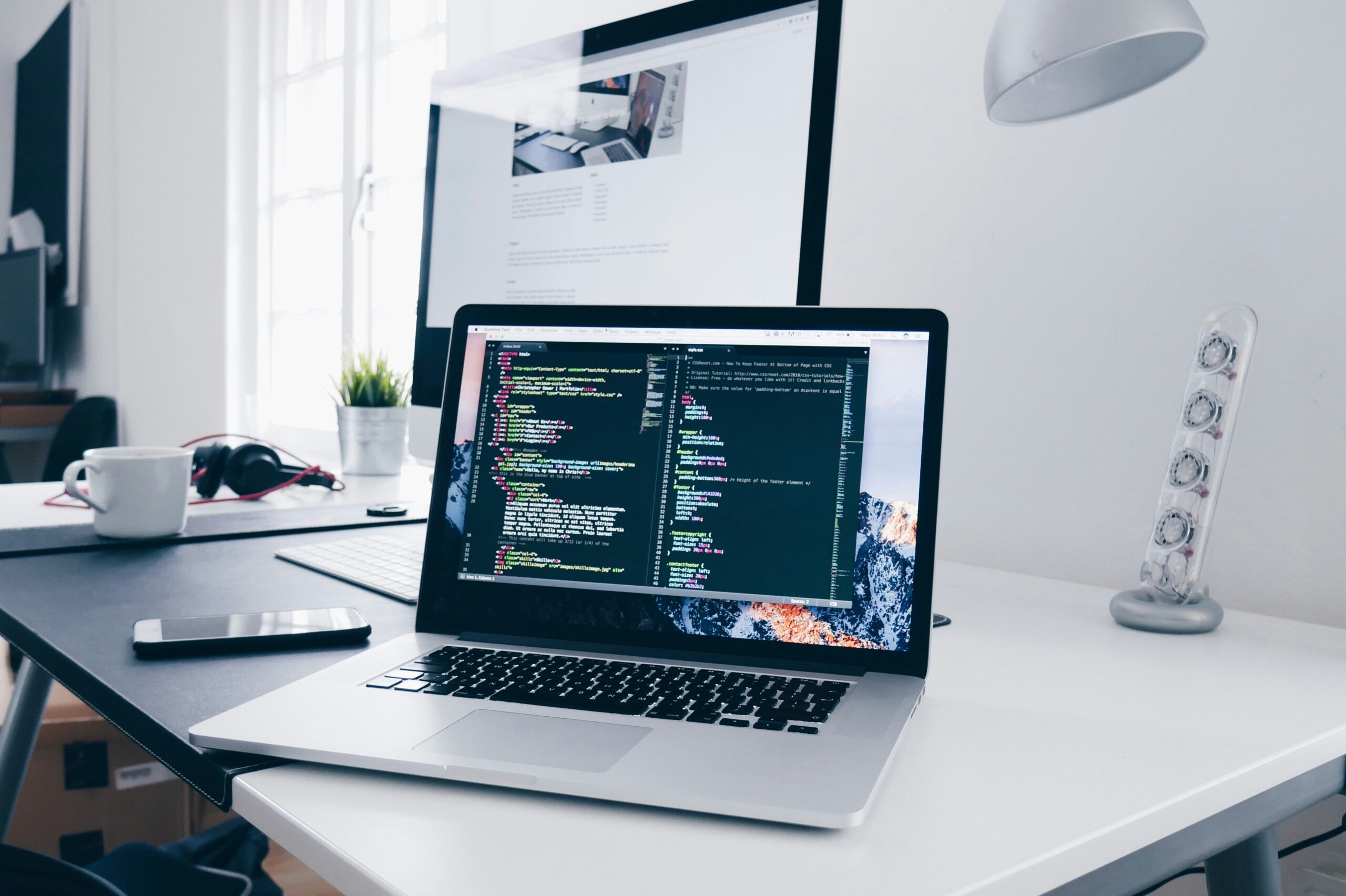 Laptop sitting on desk displaying code