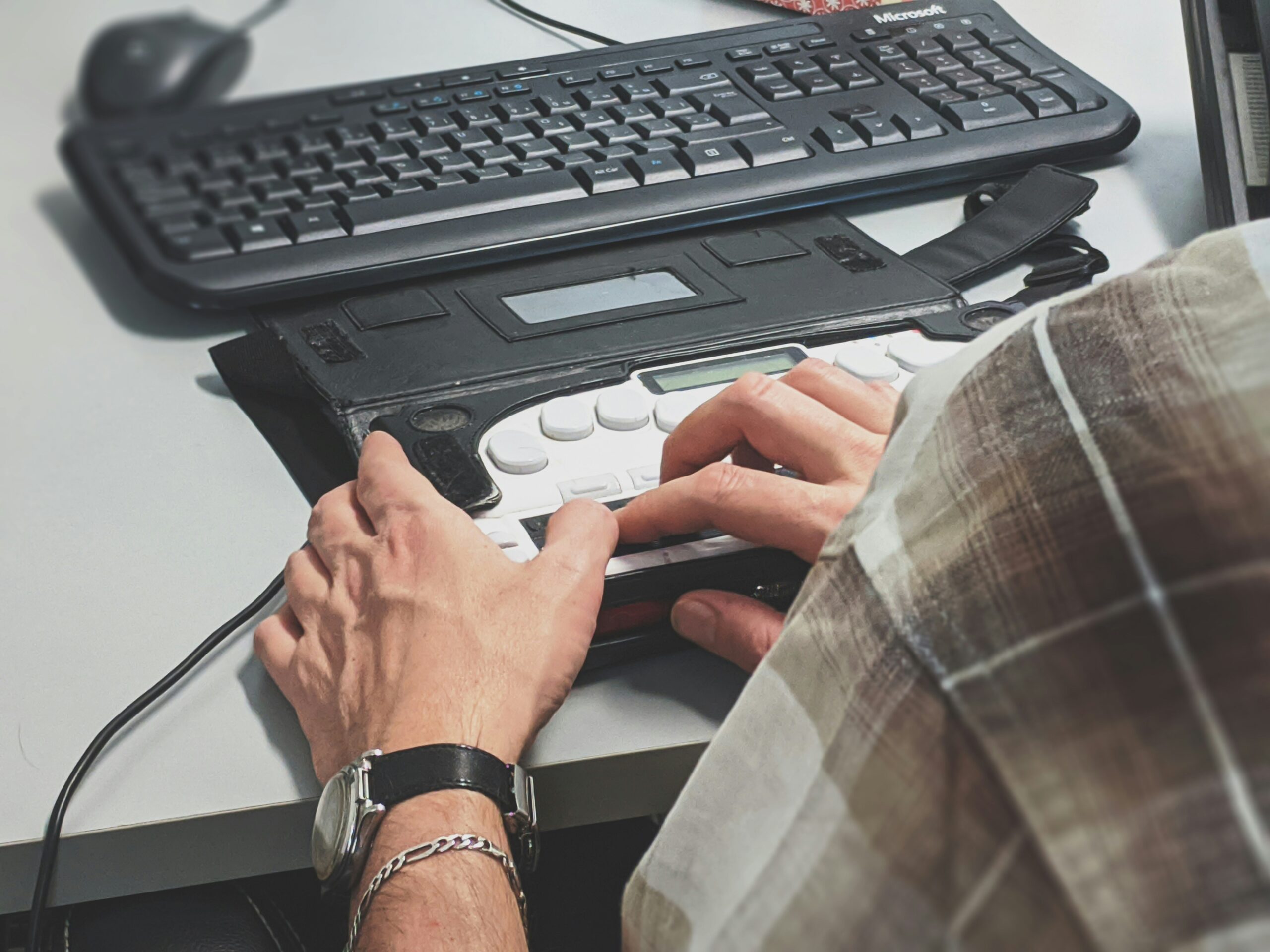 Elderly person typing on accessible keyboard